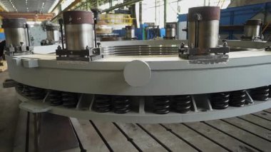Bir fabrikada yaylı ve hidrolik silindirli büyük metal bir halkanın üretim süreci