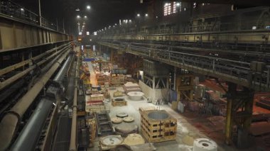 Geceleri faaliyet gösteren büyük bir endüstriyel üretim tesisinin genel görünümü