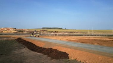 İnşaat makineleri kırsal alanda yeni bir yol inşa ediyor.