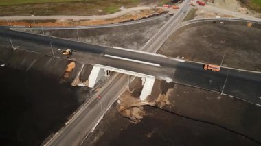 Yol yapımı sırasında köprü altından geçen kamyonlar