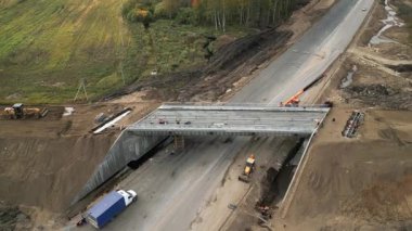 İnşaat işçileri yeni bir otoyol üst geçidi için ön döküm beton kirişler kuruyor
