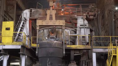 Çelik fabrikasındaki endüstriyel vinç tarafından kaldırılan erimiş metal.