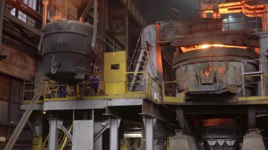 Erimiş çelik, çelik fabrikasında büyük bir kovadan fırına dökülüyor.