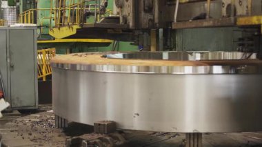 Büyük torna makinesi işleten fabrika işçisi metal halka üretiyor.