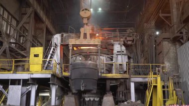 Erimiş metal çelik fabrikasındaki endüstriyel vinçle taşınıyor.
