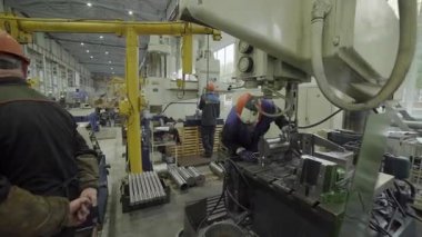 Metal işleme fabrikasında ağır makineler çalıştıran sanayi işçileri