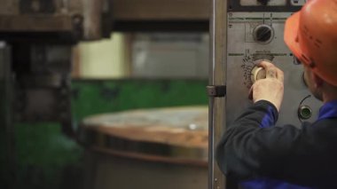 Ağır makinelerin kontrollerini ayarlayan sanayi işçisi