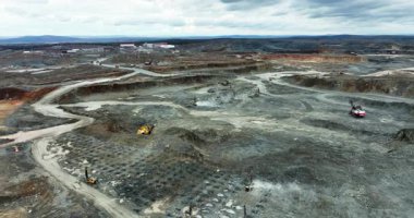 Madencilik alanında çalışan, araziyi yeniden şekillendiren ve kaynakları çıkaran ağır makineler.