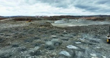 Heavy machinery working in open pit mine extracting resources and altering terrain