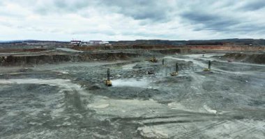 Taş ocağında çalışan, toz üreten ve araziyi değiştiren ağır makineler.