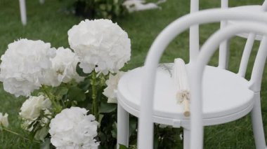 Narin beyaz çiçekleri ve minimalist sandalyeleri olan sakin bir açık hava sahnesi, unutulmaz olaylar için mükemmel.