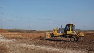 Buldozer inşaat sahasında saha temizliği yapıyor. Kırp