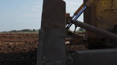 Sarı buldozer inşaat alanında toprak taşıyor. Kırp