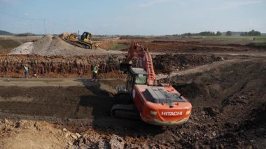 Sırbistan 'ın Vrsac kenti - Haziran 2025: Büyük kazıcı ve buldozer kırsal alanda toprak hareketinde işbirliği yapıyor. Kırp