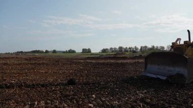 Sarı buldozer seviyeleri inşaat alanında. Kırp