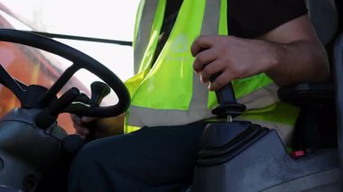 İnşaat işçisi bir kulübede kumanda kolu kullanıyor. Kırp