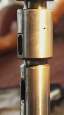 Fabrika işçileri endüstriyel şok emicisinin metal parçalarını birleştiriyorlar. Borsa klipsi 