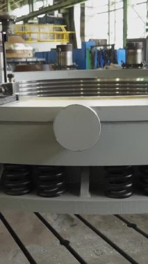 Bir fabrikada yaylı ve hidrolik silindirli büyük metal bir halkanın üretim süreci