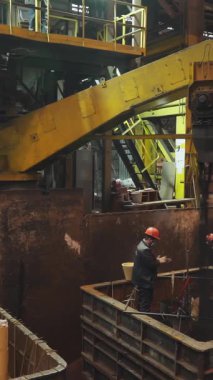 Metalürji işçileri dökümhaneye erimiş metal döküyorlar.