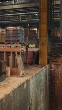 Erimiş metal, bir dökümhanede endüstriyel vinçle taşınıyor.