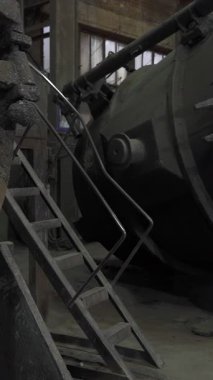 Paslı çelik kepçe endüstriyel bir ortamda yan yatar.