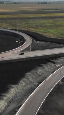 İnşaat işçileri yeni bir otoyol kavşağı inşa ediyorlar, geniş tarlalar arasında yolları birleştiriyorlar.