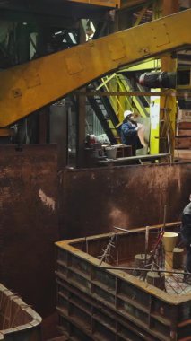 Dökümhane işçileri metal döküm için bir kalıp hazırlıyorlar. Endüstriyel imalatta güvenliği ve hassasiyeti sağlıyorlar.