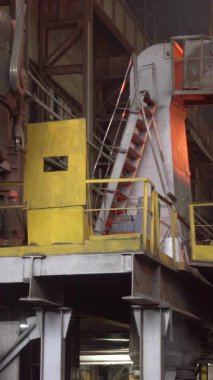 Erimiş metal, çelik fabrikasında büyük bir konteynırdan fırına dökülerek duman ve kıvılcımlar oluşturur.