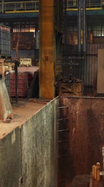 Dökümhanede endüstriyel robotik koldan erimiş metal kalıba dökülüyor