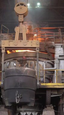 Erimiş metal çelik fabrikasındaki endüstriyel vinçle taşınıyor.