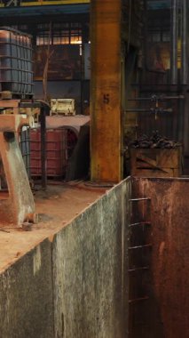 Dökümhanede erimiş metali kaldıran endüstriyel vinci kontrol eden işçiler