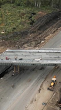 İnşaat işçileri yeni bir otoyol üst geçidi için ön döküm beton kirişler kuruyor