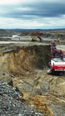 Kazıcı açık maden ocağındaki maden kamyonuna mineraller yüklüyor.