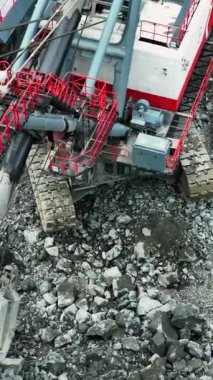 Büyük kazıcı madencilik alanında taşları çöp kamyonuna yüklüyor.