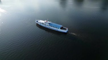 Beyaz ve mavi feribot karanlık sularda yüzüyor. Kırp