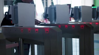 Otomatik turnikelerden geçmek için biletlerini kullanan yolcular. Medya