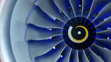 Dönen bir turbofan motorunun kapalı görüntüsü, karmaşık tasarımını ve mavi ışık efektini gösteriyor. Medya