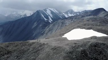 Dağ sırtında yürüyen bir grup yürüyüşçü. Medya