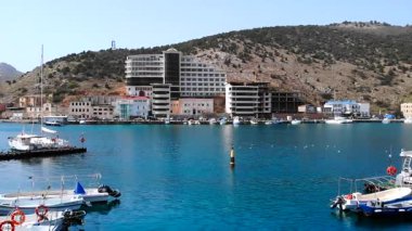 Balaklava körfezinde yüzen turistik tekneler. Arkasında binalar ve dağlar var. Medya