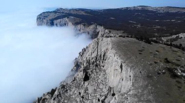 Aşağısı bulutlarla dolu muhteşem bir dağ sırtı üzerinde uçan destansı hava görüntüleri. Medya