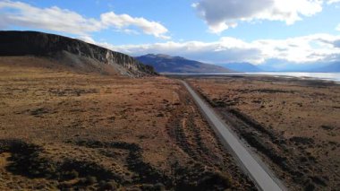Patagonya 'nın uçsuz bucaksız kurak arazisinde uzanan terk edilmiş asfalt bir yolun havadan bakış açısı. Medya