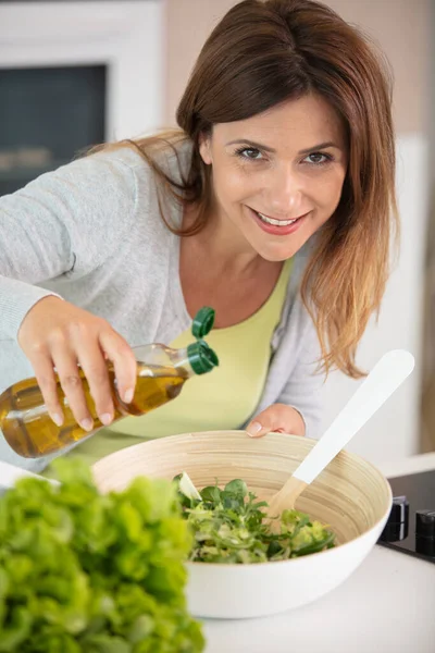 Junge Frau Würzt Gemüsesalat Mit Oliven — Stockfoto