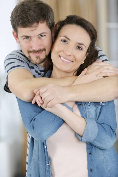 微笑的中年夫妇站在全新的家 — 图库照片