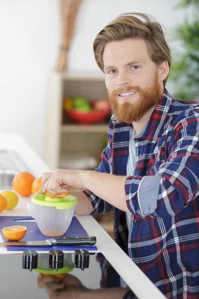 Junger Mann Macht Orangensaft Küche — Stockfoto