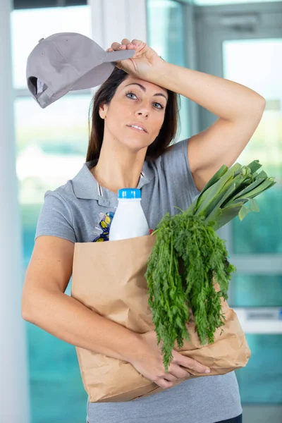 deliverywoman holding groceries bag for delivery to client