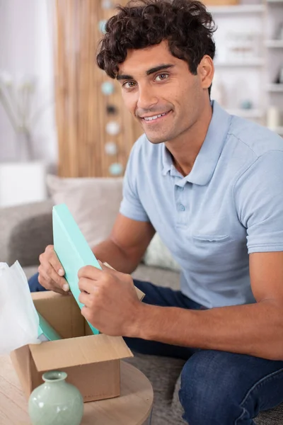 Handsome Young Man Opening Parcel While Sitting Sofa — Stock Photo, Image