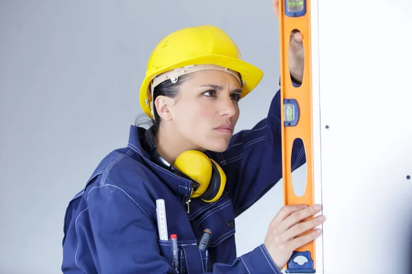 Mujer Constructora Hardhat Haciendo Medidas Con Herramienta Nivel —  Fotos de Stock