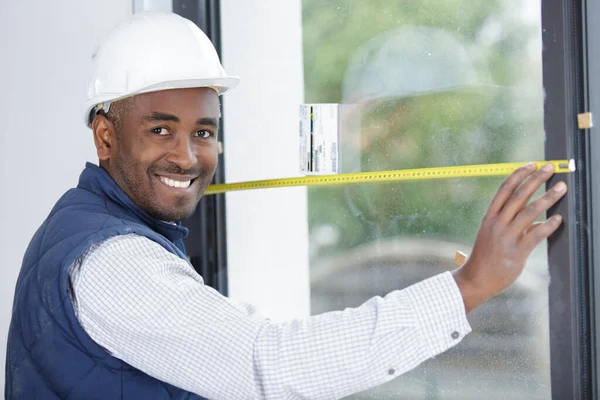 窓を測定する笑顔の労働者 — ストック写真