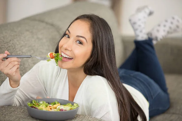 Frau Genießt Salat Der Auf Dem Sofa Liegt — Stockfoto