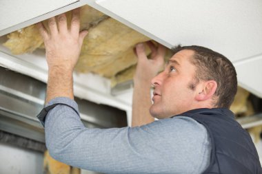 caucasian man fixes ceiling skirting clipart